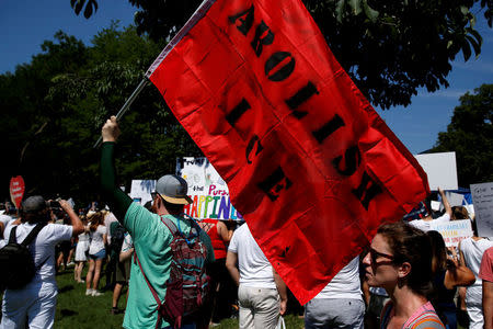 An immigration activists carries a flag calling for the abolishment of ICE, U.S. Immigration and Customs Enforcement, during rally to protest against the Trump Administration's immigration policy outside the White House in Washington, U.S., June 30, 2018. REUTERS/Joshua Roberts