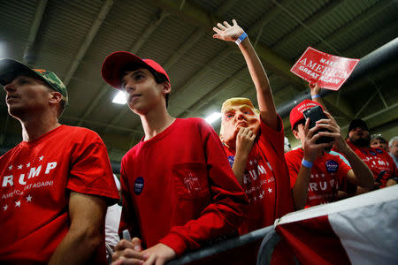 A boy wears a Trump mask and tries to get Trump's attention onstage as supporters rally with Republican U.S. presidential nominee Donald Trump in Fletcher, North Carolina, U.S. October 21, 2016. REUTERS/Jonathan Ernst