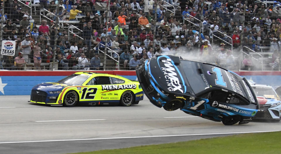Ryan Blaney (12) passes by Ross Chastain (1) lifting off the track after making contact with Kyle Busch, right, during the NASCAR All-Star auto race at Texas Motor Speedway in Fort Worth, Texas, Sunday, May 22, 2022. (AP Photo/Randy Holt)