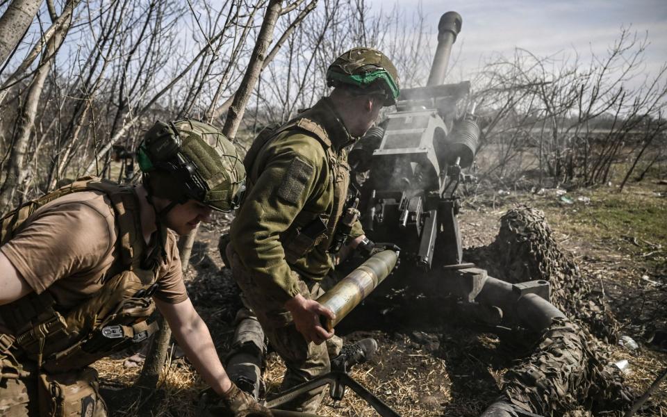 Ukrainian servicemen fire with an M119 105mm howitzer at Russian positions near Bakhmut - ARIS MESSINIS/AFP