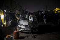 Farmer Ravinder Singh, 21, leans on the bonnet of his car parked on a highway as a sign of protest against new farm bills, at the Delhi-Haryana state border, India, Wednesday, Dec. 2, 2020. The farmers are protesting new laws they say will result in their exploitation by corporations, eventually rendering them landless. Prime Minister Narendra Modi's government, rattled by the growing rebellion, insists the reforms will benefit them. But the farmers aren’t yielding. (AP Photo/Altaf Qadri)