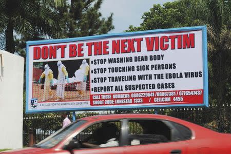 A car drives past a public health advertisement against the Ebola virus in Monrovia October 8, 2014. REUTERS/James Giahyue