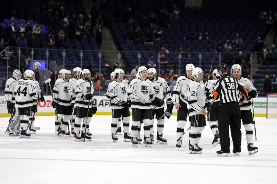 The Los Angeles Kings line up to shake hands with referee Dean Morton (26) after an NHL hockey game against the New York Islanders on Thursday, Jan. 27, 2022, in Elmont, N.Y. The Kings won 3-2. (AP Photo/Adam Hunger)