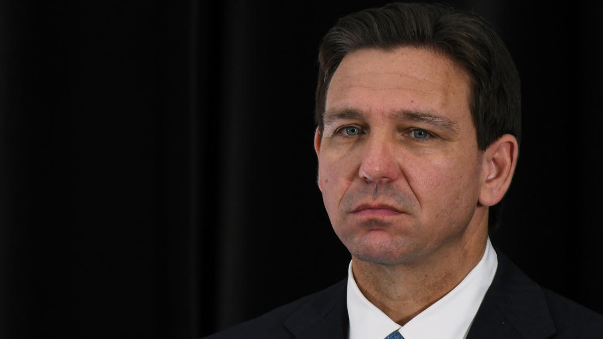 Florida Governor Ron DeSantis listens to a speaker at a press conference.