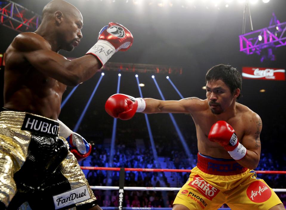 Floyd Mayweather, Jr. of the U.S. (L) and Manny Pacquiao of the Philippines fight in the first round of their welterweight WBO, WBC and WBA (Super) title fight in Las Vegas, Nevada, May 2, 2015. REUTERS/Steve Marcus