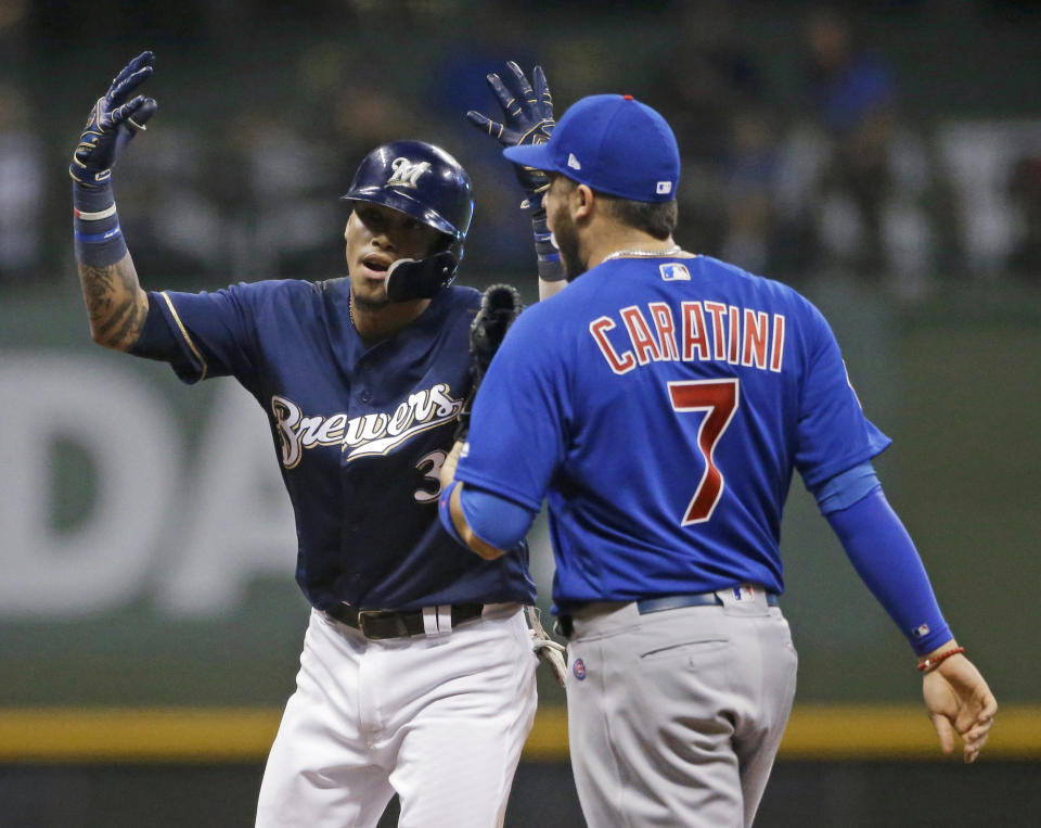 Milwaukee Brewers' Orlando Arcia reacts next to Chicago Cubs' Victor Caratini (7) after hitting a double during the seventh inning of a baseball game Tuesday, Sept. 4, 2018, in Milwaukee. (AP Photo/Aaron Gash)