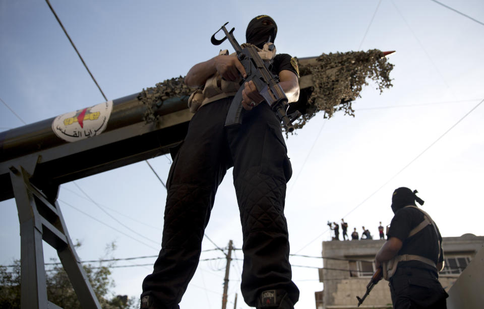 FILE - In this Oct. 4, 2018 file photo, Palestinian members of the Al-Quds Brigades, the military wing of the Islamic Jihad group, march with their weapons to show loyalty for the Iranian-backed Palestinian movement's newly elected leader Ziad al-Nakhalah in the streets of Gaza. Islamic Jihad is the smaller of the two main Palestinian militant groups in the Gaza Strip, and is vastly outnumbered by the ruling Hamas group. But it enjoys direct Iranian backing, both financially and militarily, and has become the driving force in rocket fire and confrontations with Israel. (AP Photo/Hatem Moussa, File)