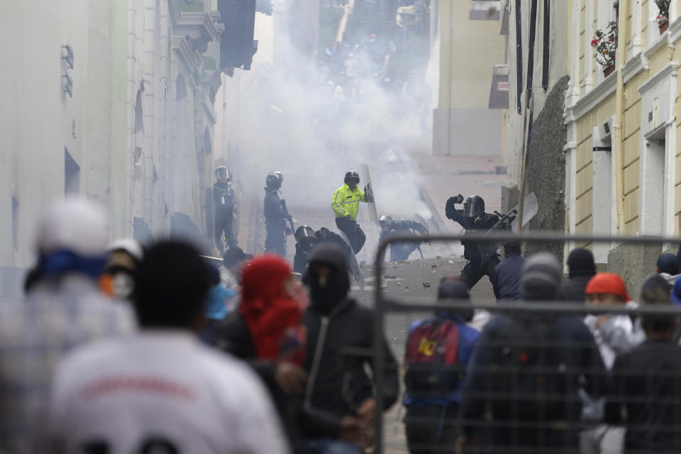 Anti-government demonstrators and security forces face off during a nationwide strike march against President Lenin Moreno and his economic policies, in Quito, Ecuador, Wednesday, Oct. 9, 2019. Ecuador's military has warned people who plan to participate in a national strike over fuel price hikes to avoid acts of violence, saying it will enforce order. (AP Photo/Fernando Vergara)