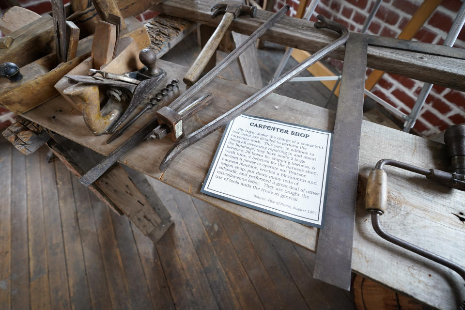 Tools used in a carpenter shop are seen on display in a museum at the former Genoa Indian Industrial School, Thursday, Oct. 27, 2022, in Genoa, Neb. For decades the location of the student cemetery, where over 80 Native American children are buried, has been a mystery, lost over time after the school closed in 1931 and memories faded of the once-busy campus that sprawled over 640 acres in the tiny community of Genoa. (AP Photo/Charlie Neibergall)