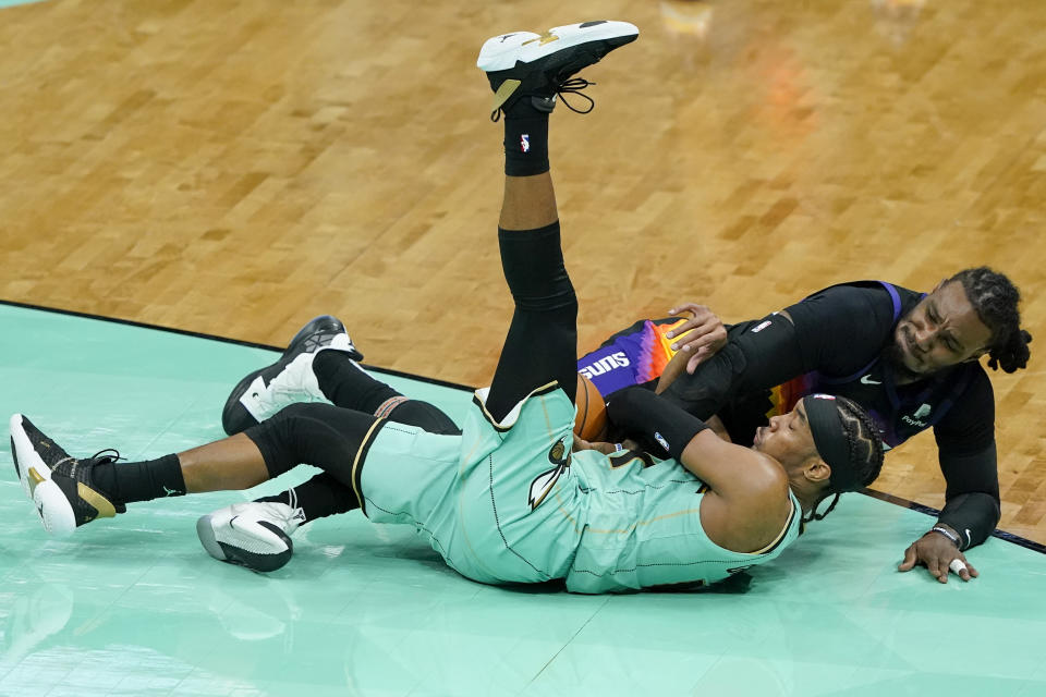 Charlotte Hornets guard Devonte' Graham and Phoenix Suns forward Jae Crowder battle for a loose ball during the second half of an NBA basketball game on Sunday, March 28, 2021, in Charlotte, N.C. (AP Photo/Chris Carlson)