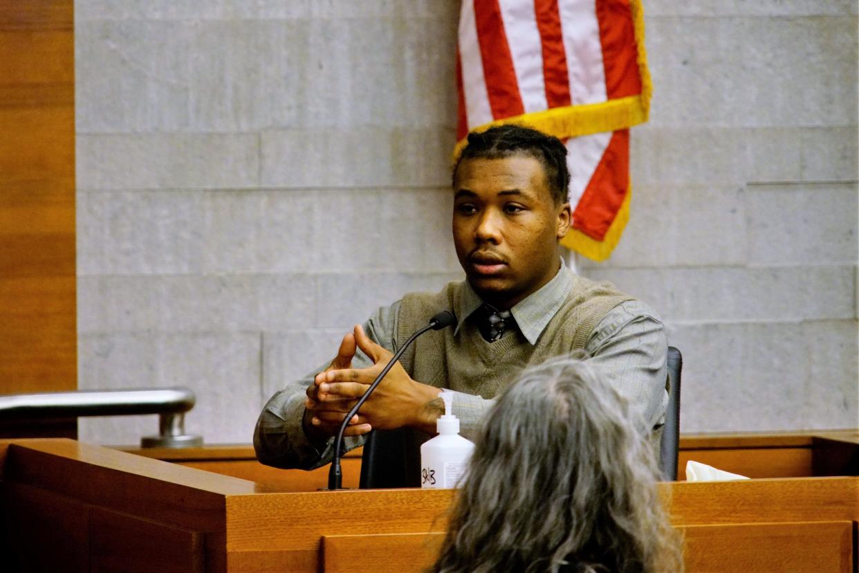 Testifying on Dec. 13, 2023, during his murder trial in Franklin County Common Pleas Court, Kyrique Camper demonstrates how he said a shadowy figure approached his car with their "hands like this" at a stoplight on Oct. 17, 2022. Camper said that he could not see who was approaching because it was nighttime and his car windows were tinted, but said he feared the person was going to shoot him so he fired a single shot that ultimately killed 17-year-old A'niyah Elie. The jury acquitted Camper of murder, but found him guilty of improperly handling a firearm. He was sentenced to two years of probation.