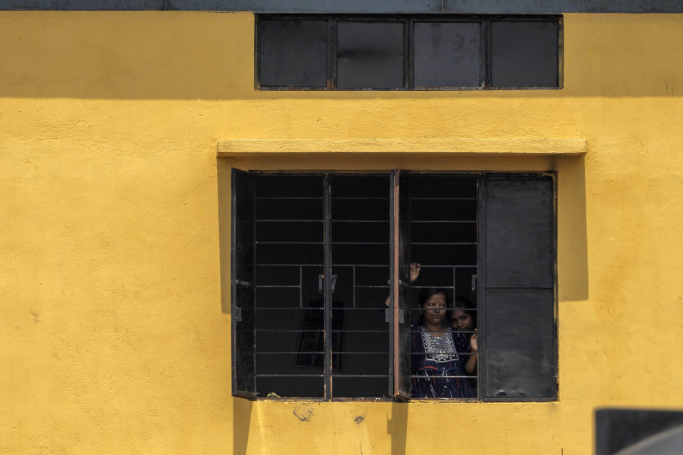 Two detainees look out through a window of a detention center where where suspected immigrants are held in Matiya village, northeastern Assam state, India, April 17, 2023. Nearly 2 million people, or over 5% of Assam's population, could be stripped of their citizenship unless they have documents dating back to 1971 that show their ancestors entered the country legally from neighboring Bangladesh. (AP Photo/Anupam Nath)