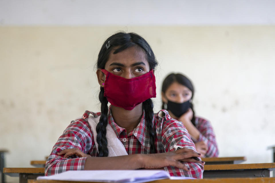 Students wear masks and sit following social distancing measures as a precautionary measure against the coronavirus, as they attend a class at the Government Senior Secondary School in Dari, near Dharmsala, India, Friday, Nov. 6, 2020. (AP Photo/Ashwini Bhatia)