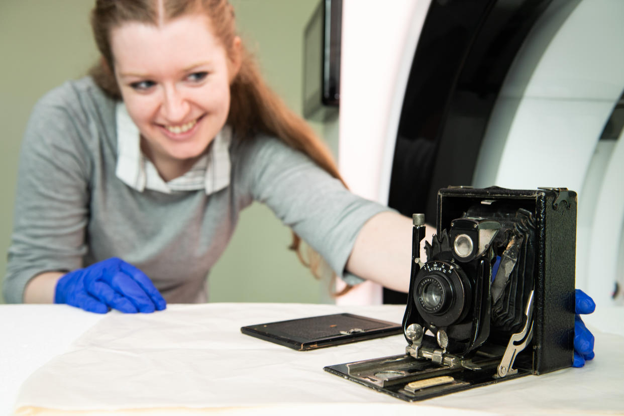 A woman positioning a camera on a scanner