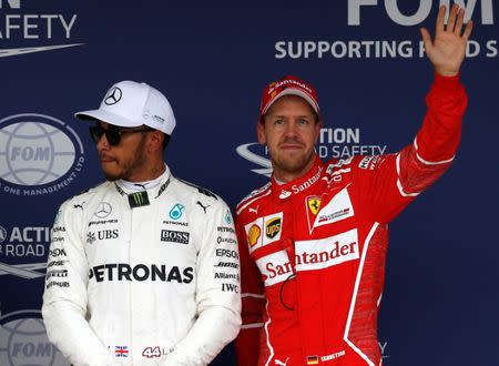 FILE PHOTO - Formula One F1 - Japanese Grand Prix 2017 - Suzuka Circuit, Japan - October 7, 2017. Ferrari's Sebastian Vettel of Germany waves after finishing third next to Mercedes' Lewis Hamilton of Britain after qualifying. REUTERS/Toru Hanai