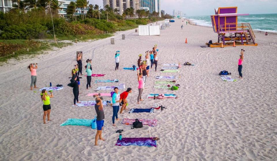 Certified personal trainer Kristen Smith (far right) leads a fitness class in the sand on Tuesday, Jan. 23, 2024 as part of her early morning Miami Beach Fit Camp program. She used to weigh 405 pounds and has lost more than 240 pounds since 2006. She will run her first Life Time Miami Marathon on Sunday, Jan. 28th. Pedro Portal/pportal@miamiherald.com