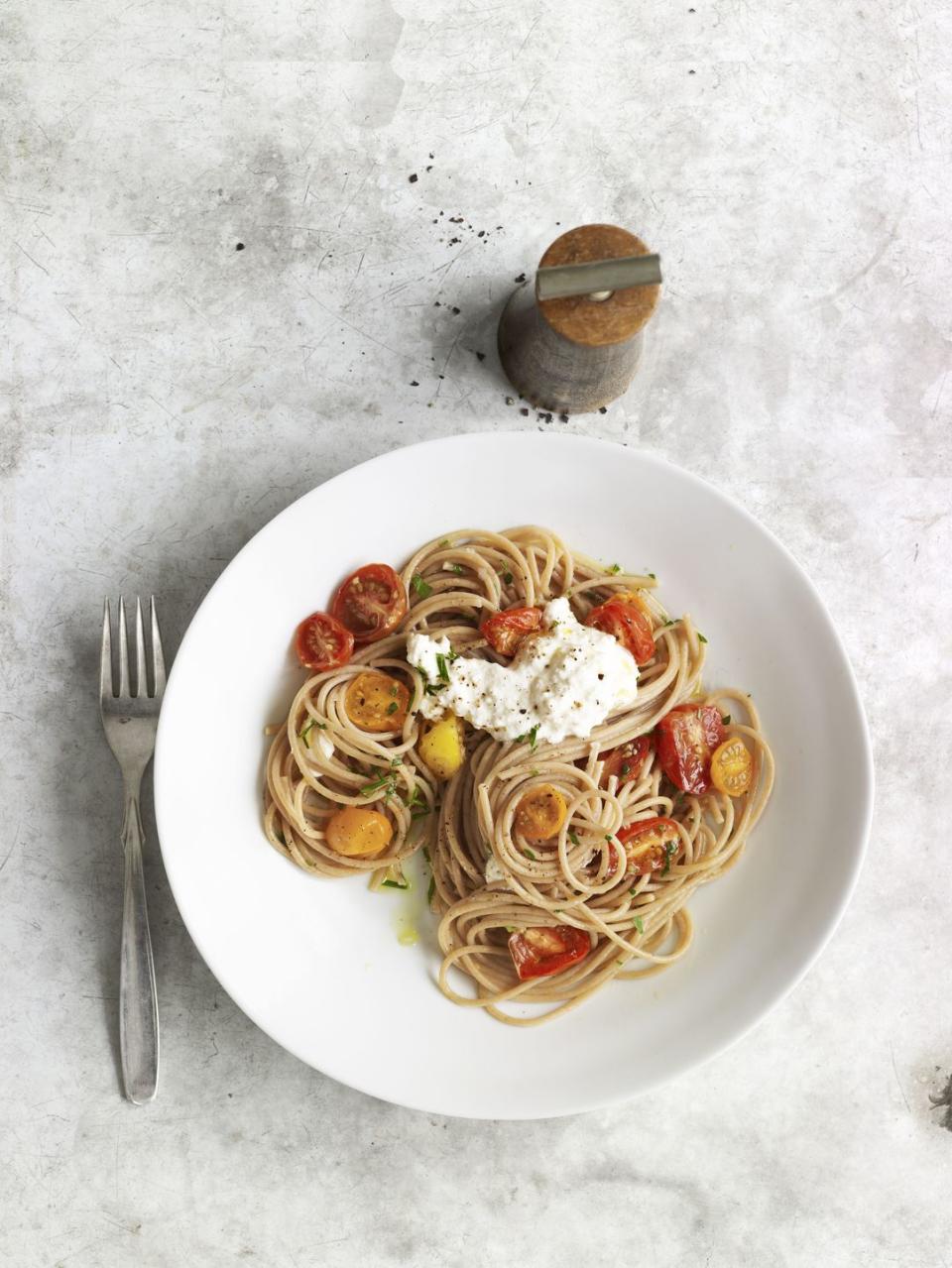 whole wheat spaghetti with cherry tomatoes and ricotta cheese on a white plate