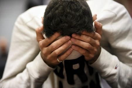 The 18-year-old Moroccan Ilyas Berrouh, covers his face during the initial remand hearing of suspects of killing two people and attempting to kill eight others with terrorist intent (with reasonable doubt) in Turku last week, at the Southwest Finland District Court in Turku, Finland, August 22, 2017. Martti Kainulainen via REUTERS