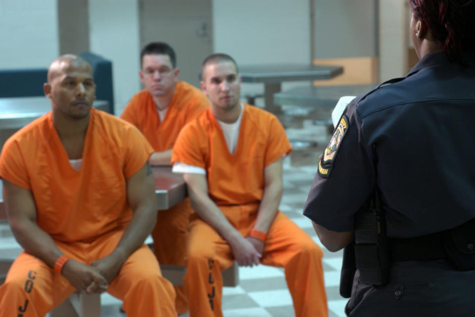 Prison inmates paying attention to a guard