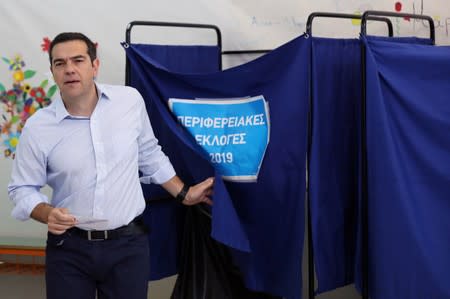 Greek Prime Minister Alexis Tsipras exits the polling booth before voting for the second round of local elections in Athens