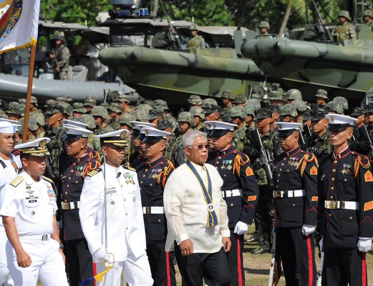 Philippine defense secretary Voltaire Gazmin (front R) inspects personnel during the navy's founding anniversary celebration at a naval station in Cavite city, west of Manila on May 25, 2015