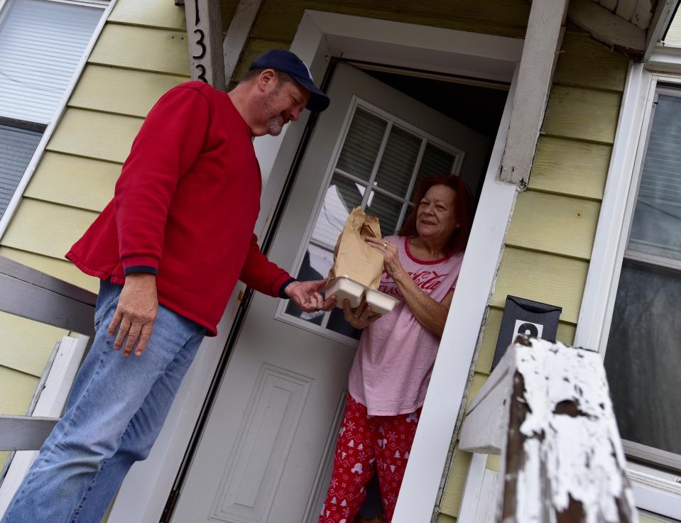 Joanna Marley smiles as she's handed a pre-made meal delivered by Dan Shelton on Wednesday, Nov. 16, 2022.