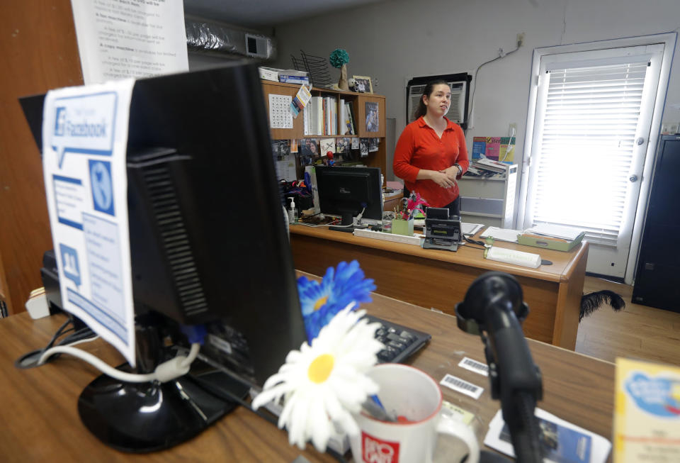 Library Director Jennifer Ramirez advises a visitor that she is unable to assist him with his request because most of the computers at the public library in Wilmer, Texas, were not working on Thursday, Aug. 22, 2019. Cyberattacks that recently crippled nearly two dozen Texas cities have put other local governments on guard. (AP Photo/Tony Gutierrez)