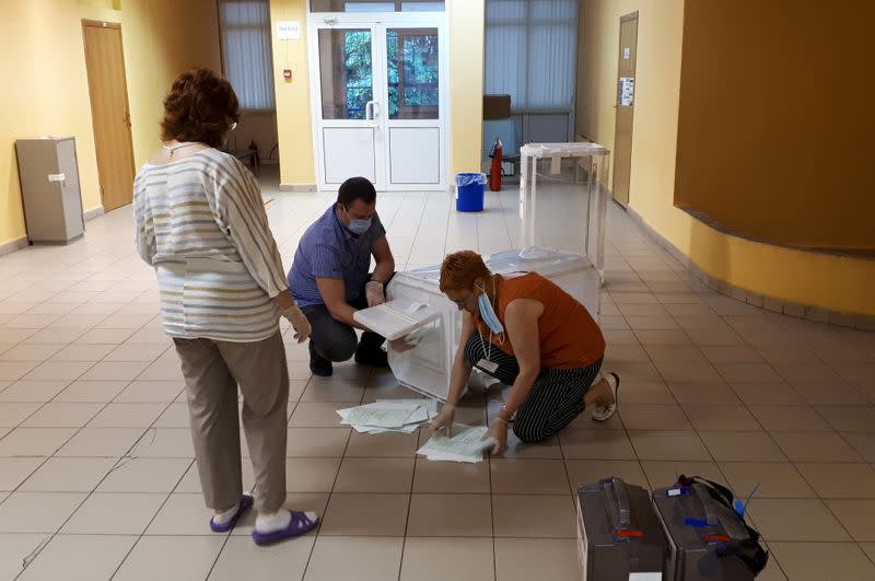 Members of a local electoral commission empty a ballot box at a polling station during a seven-day nationwide vote on constitutional reforms in Reutov