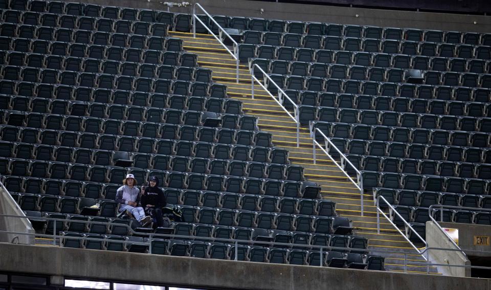 Two fans have the upper deck to themselves during a recent A's game at RingCentral Coliseum in Oakland.