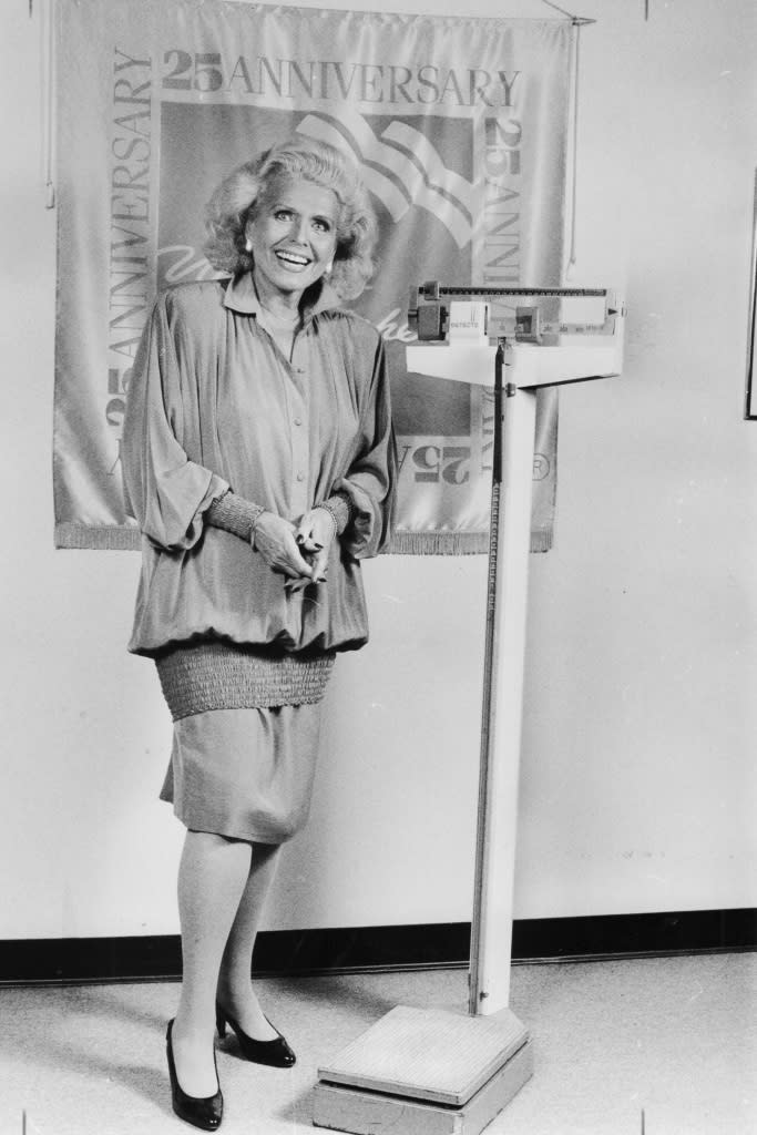 Jean Nidetch, founder of Weight Watchers, stands next to a scale in a meeting room at the company's headquarters in Manhattan on September 20, 1988. (Photo by Susan Farley/Newsday RM via Getty Images)