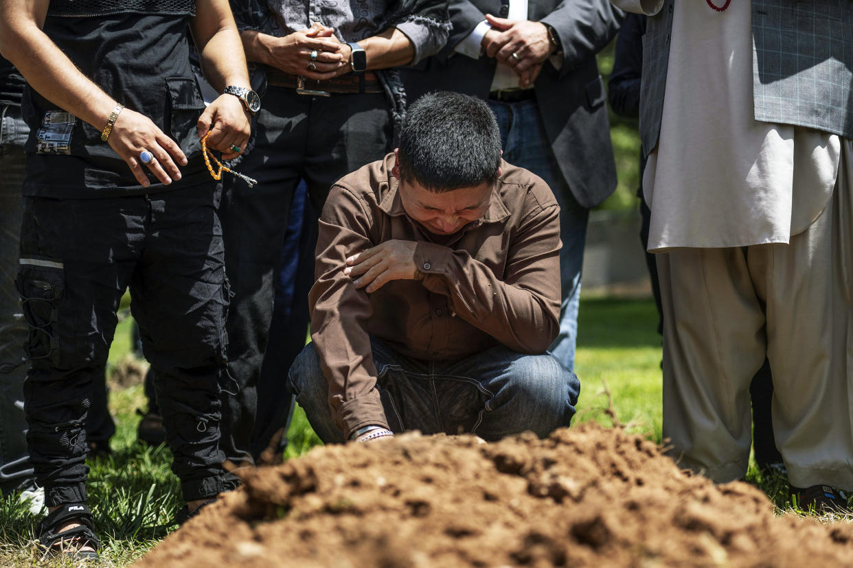 Altaf Hussain cries over the grave of his brother Aftab Hussein at Fairview Memorial Park in Albuquerque, N.M., on Aug. 5, 2022. (Chancey Bush / AP)