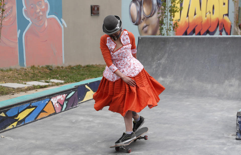 Yanira Villarreal, wearing a mask amid the COVID-19 pandemic and dressed as a "Cholita" rides a skateboard during a youth talent show in La Paz, Bolivia, Wednesday, Sept. 30, 2020. Young women called "Skates Imillas," using the Aymara word for girl Imilla, use traditional Indigenous clothing as a statement of pride of their Indigenous culture while playing riding their skateboards. (AP Photo/Juan Karita)