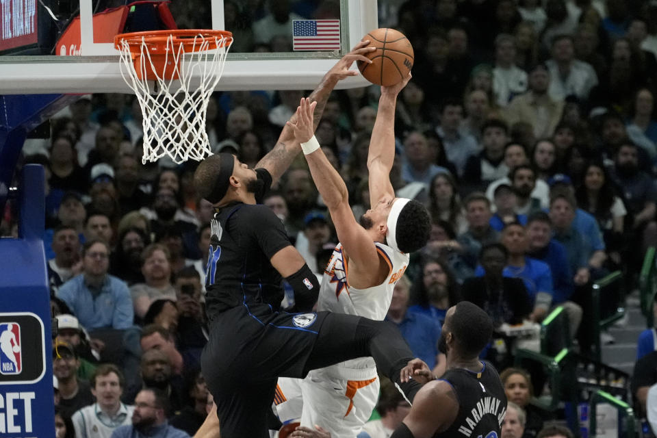 Dallas Mavericks' Daniel Gafford, left, blocks a shot-attempt by Phoenix Suns' Devin Booker, top right, in the second half of an NBA basketball game in Dallas, Thursday, Feb. 22, 2024. (AP Photo/Tony Gutierrez)