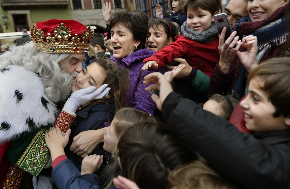 <p>A man dressed as one of the Three Wise Men kisses a child upon arriving at Poniente beach in Gijon, Spain, Jan. 5, 2018. (Photo: Eloy Alonso/Reuters) </p>