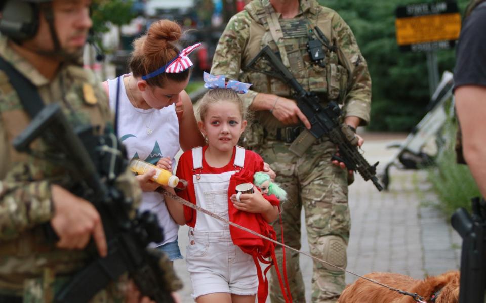 Police officers escort people to safety during Monday's shooting - GETTY IMAGES