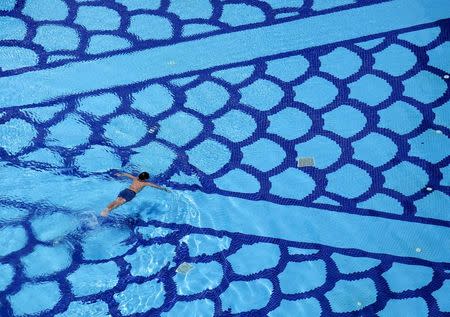 A man swims in a pool inside a condominium in Singapore in this March 21, 2010 file photo. REUTERS/Nicky Loh/Files