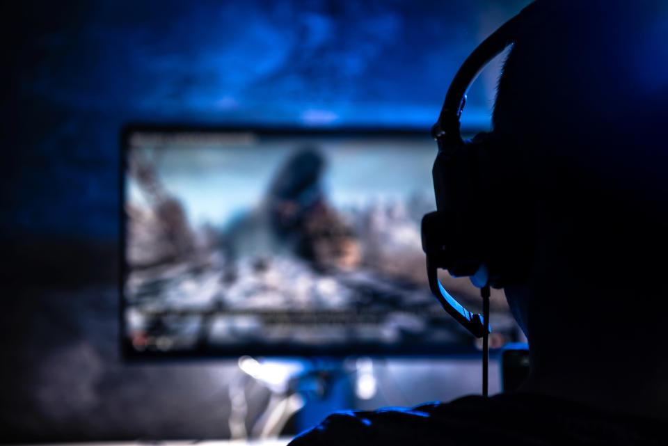 A person wearing headphones and looking at a monitor.