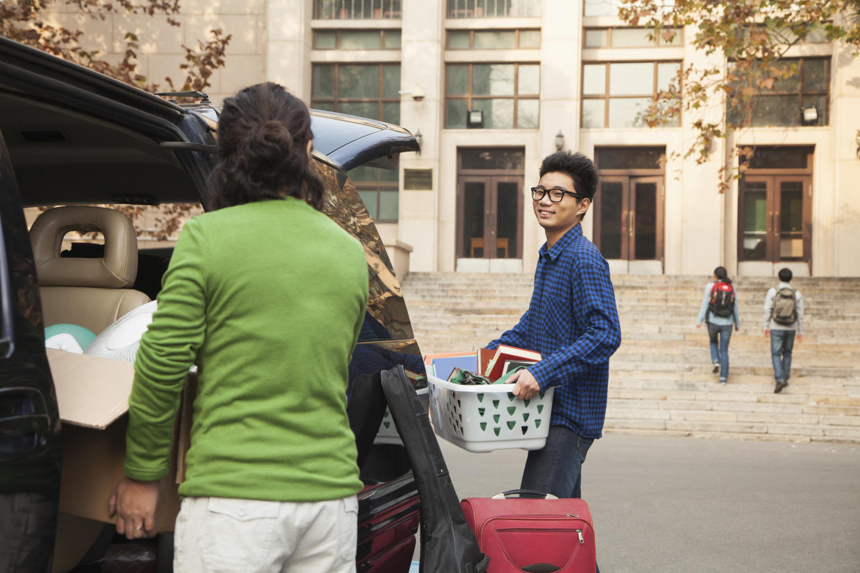 Young man moving into dormitory on college campus