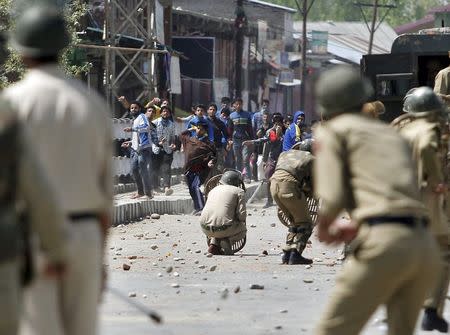 Kashmiri protesters throw stones towards Indian policemen during a daylong protest strike in Narbal, north of Srinagar April 18, 2015. REUTERS/Danish Ismail