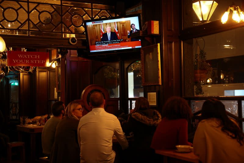 People watch Britain's Prime Minister Boris Johnson announce new lockdown measures inside a pub in Westminster, amid the coronavirus disease (COVID-19) outbreak, in London