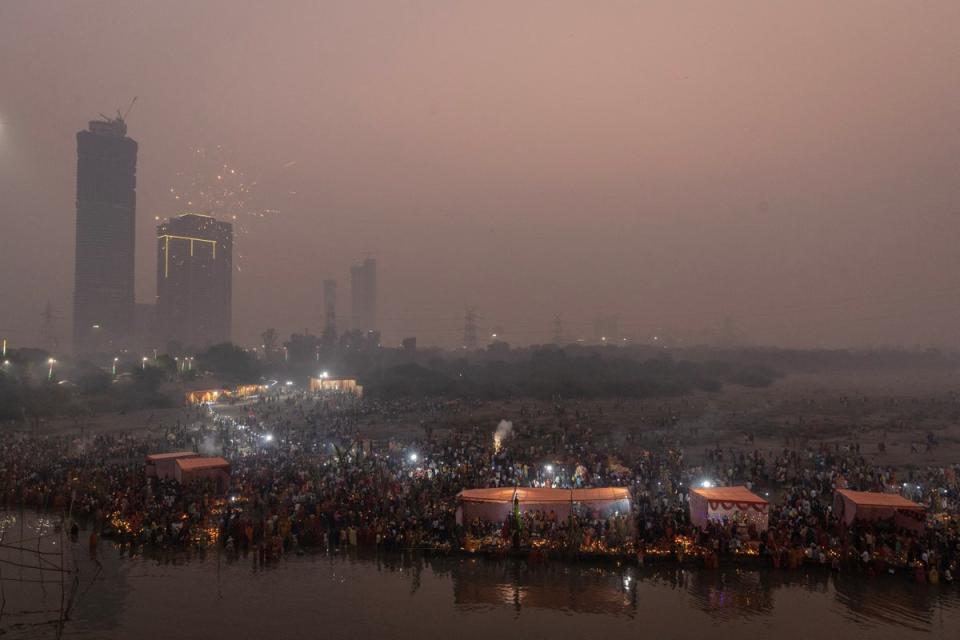 Hindu devotees gather to worship the sun god Surya in the early morning during the Hindu festival of Chhath Puja (Reuters)