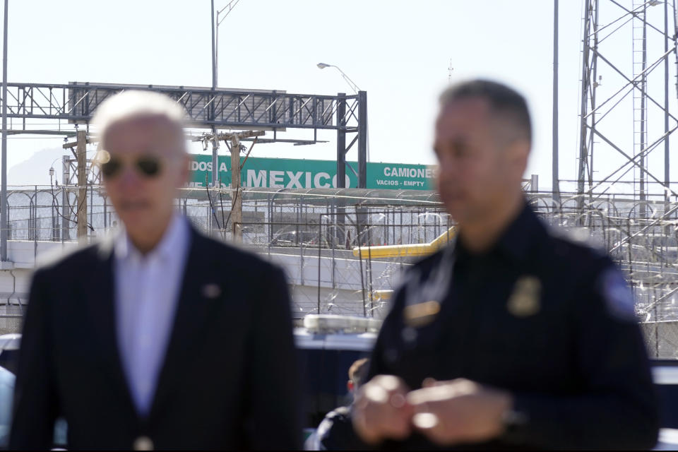 Un letrero grande de "Bienvenidos a México" puede apreciarse sobre el Puente de las Américas detrás del presidente Joe Biden y un agente de la Oficina de Aduanas y Protección Fronteriza mientras recorren un puerto de entrada, el domingo 8 de enero de 2023, en El Paso, Texas. (AP Foto/Andrew Harnik)