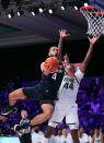 In this photo provided by Bahamas Visual Services, Connecticut guard Tyrese Martin (4) goes to the basket as Michigan State forward Gabe Brown (44) defends during an NCAA college basketball game at Paradise Island, Bahamas, Thursday, Nov. 25, 2021. (Tim Aylen/Bahamas Visual Services via AP)