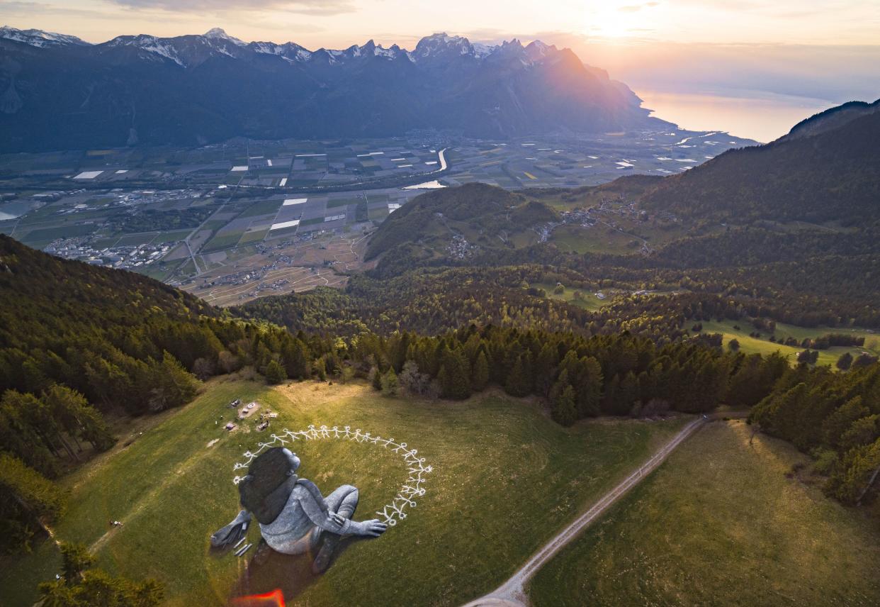 A giant land art painting, entitled "Beyond Crisis," by Swiss French artist Saype can be seen in the alpine resort of Leysin, Switzerland on Friday, April 24, 2020. The artwork covering 3000 square meters was produced with biodegradable paints made from natural pigments such as coal and chalk. The artist aims to send a message of hope and positivity to the world in the difficult times of the COVID-19 pandemic.