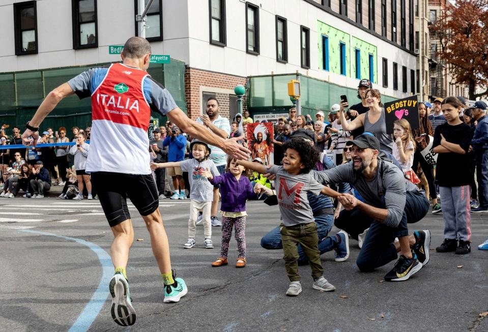 A runner high-fives spectators during the 2022 New York City Marathon on Nov. 6, 2022. In the largest marathon in the world, more than 50,000 runners made their way through all five boroughs of New York City on the 26.2-mile course.