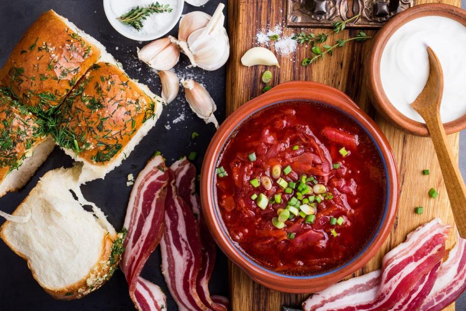 Borsch in a ceramic bowl with pampushky garlic buns and dry cured pork belly. (Getty Images)