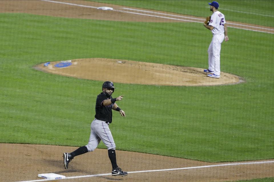 Miami Marlins' Francisco Cervelli gestures to teammates as he runs the bases after hitting a three-run home run during the second inning of a baseball game as New York Mets starting pitcher Michael Wacha, right, reacts Friday, Aug. 7, 2020, in New York. (AP Photo/Frank Franklin II)