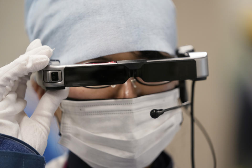 A lab technician uses a pair of smart glasses as she demonstrates a part of a process to measure levels of tritium in water samples at one of the two laboratories at the Fukushima Daiichi nuclear power plant, run by Tokyo Electric Power Company Holdings (TEPCO), in Okuma town, northeastern Japan, Thursday, March 3, 2022. TEPCO and government officials say tritium, which is not harmful in small amounts, is inseparable from the water, but all other 63 radioactive isotopes selected for treatment can be reduced to safe levels, tested and further diluted by seawater before release. (AP Photo/Hiro Komae)