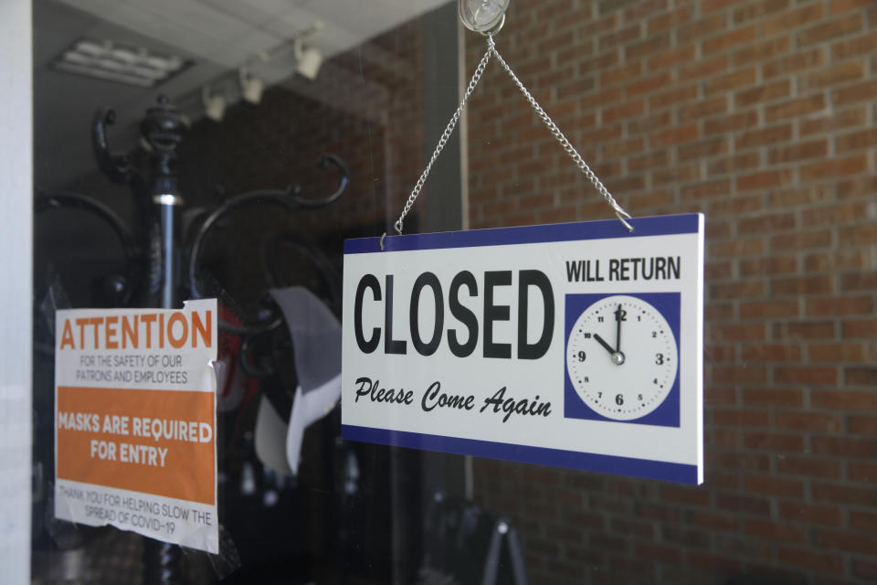 FILE - In this July 18, 2020 file photo a closed sign hangs in the window of a barber shop in Burbank, Calif. California's unemployment rate has fallen to 11.4% in August. The Employment Development Department says the state added 101,900 jobs in August. Most of those were government jobs, including temporary positions for the U.S. Census. California lost more than 2.6 million jobs in March and April because of the coronavirus. (AP Photo/Marcio Jose Sanchez, File)