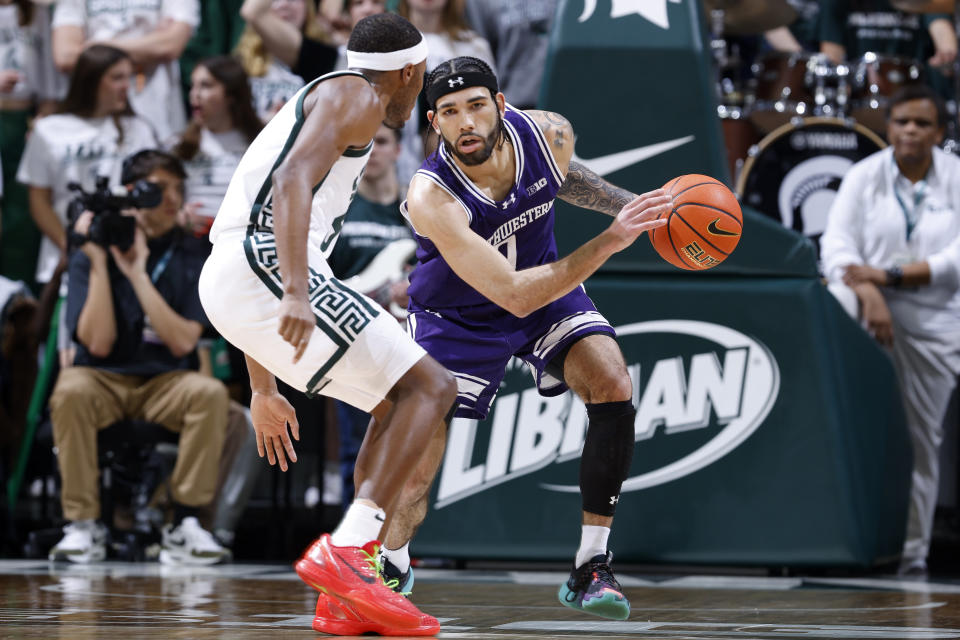 Northwestern guard Boo Buie (0), right, drives against Michigan State guard Tre Holloman during the first half of an NCAA college basketball game, Wednesday, March 6, 2024, in East Lansing, Mich. (AP Photo/Al Goldis)